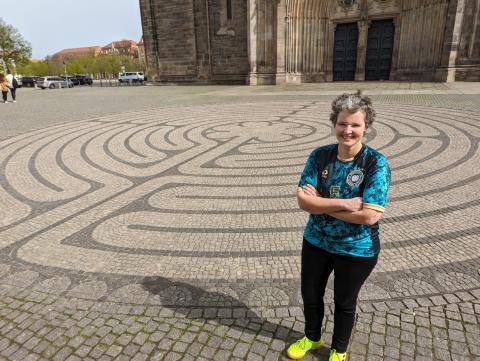 Eine Frau vor einem Bodenlabyrinth