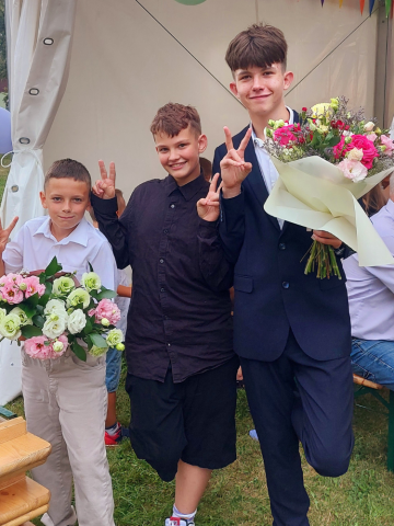 Drei Jungen halten Blumensträuße in der Hand