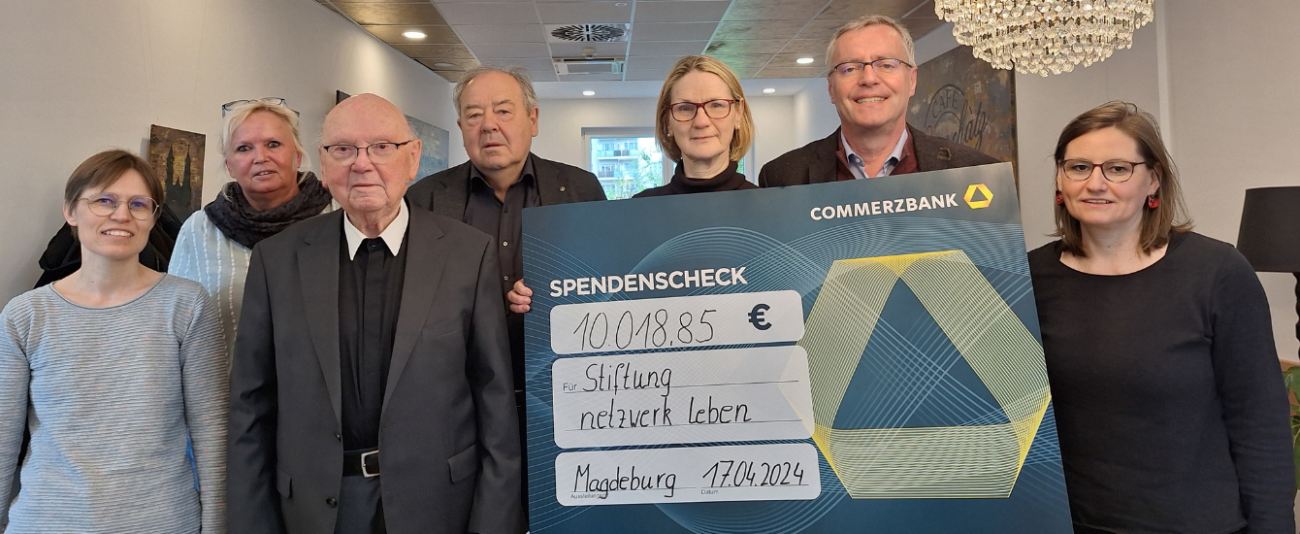 Menschen halten einen großen Spendenscheck 