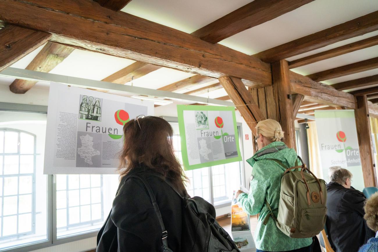 Frauen stehen vor Plakaten