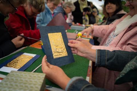 Eine Hand hält ein goldenes Plättchen