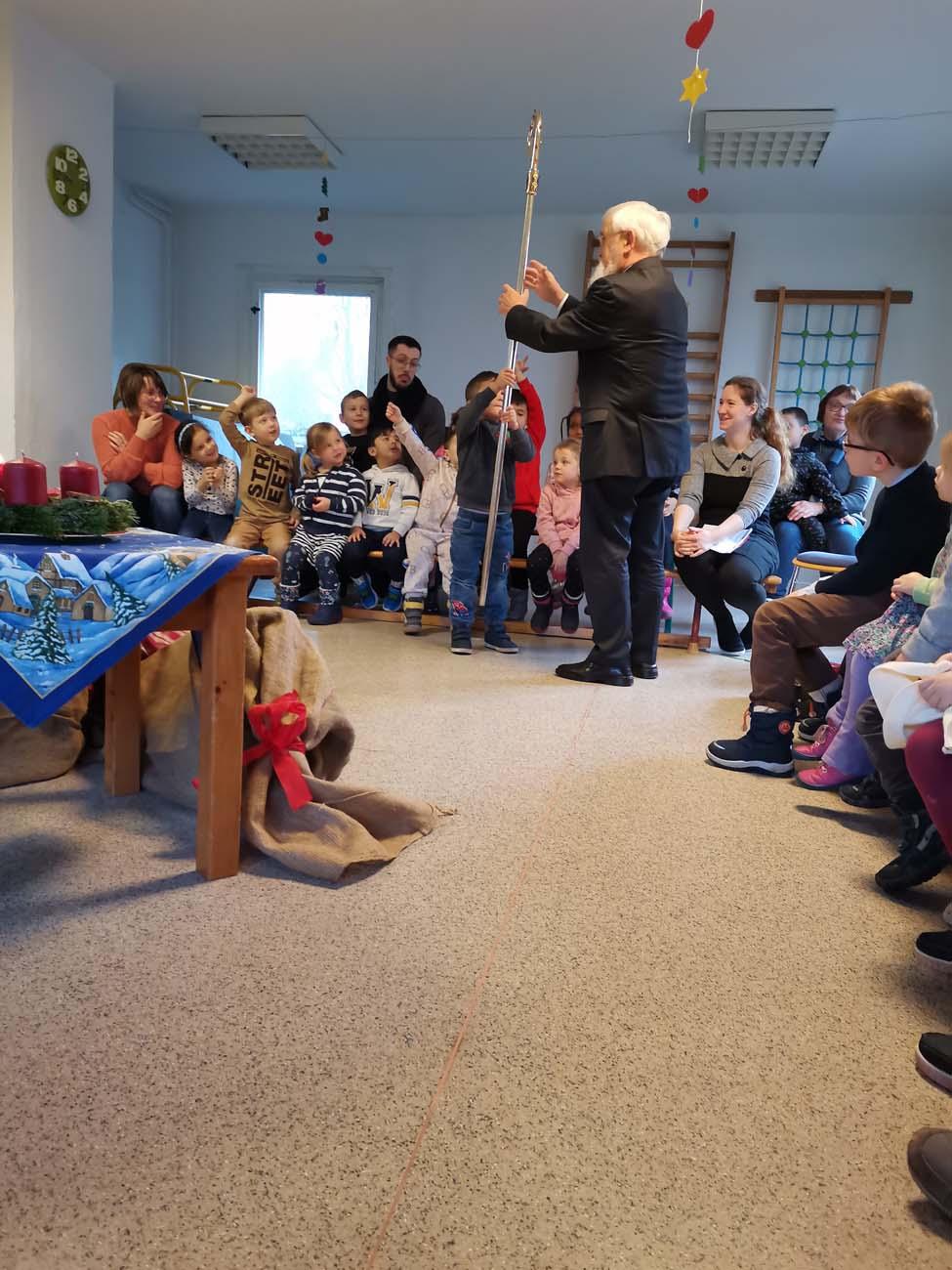 Bischof mit Kindern in einem Raum