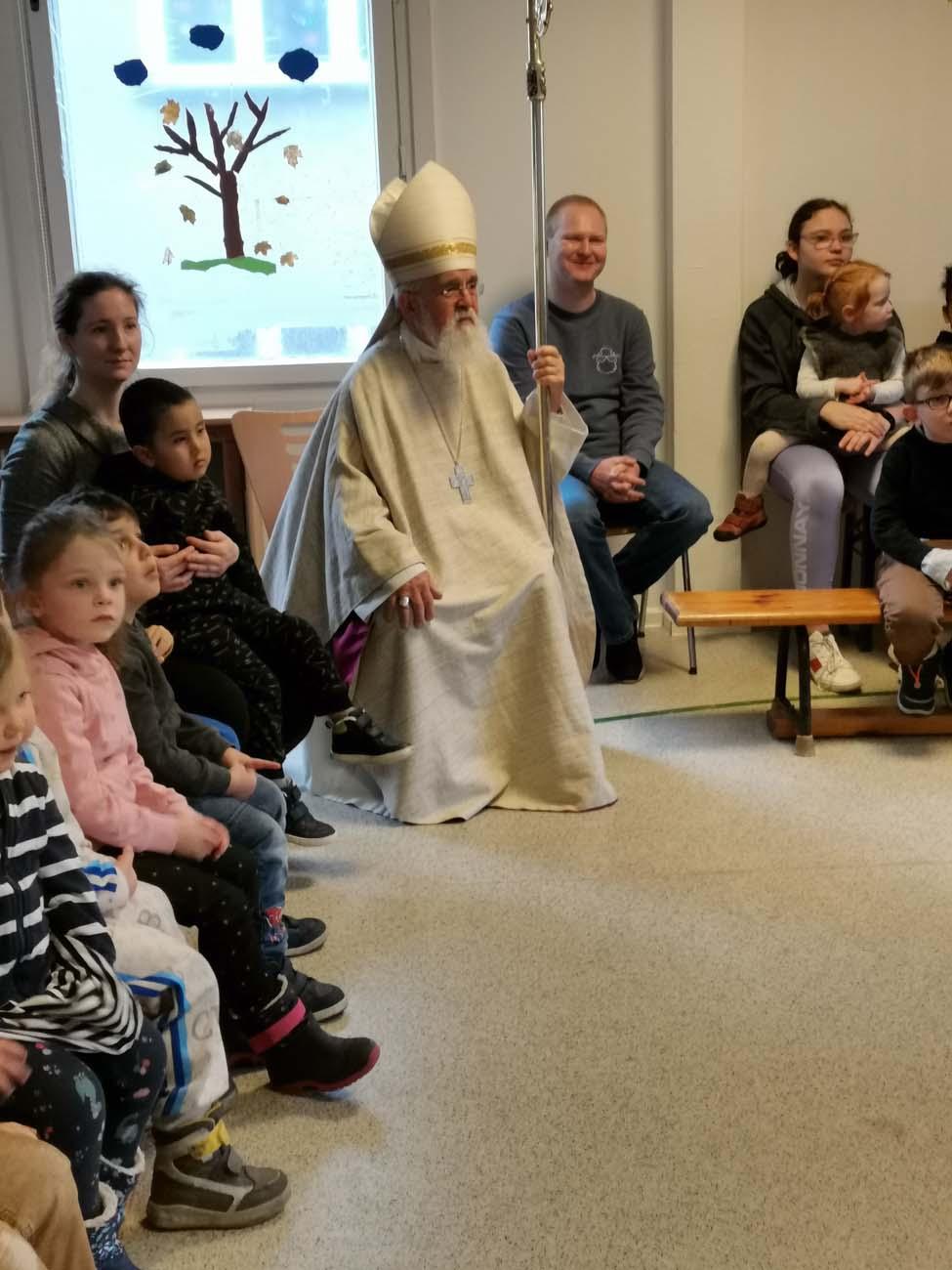 Bischof mit Kindern in einem Raum