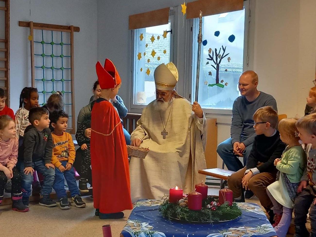 Bischof mit Kindern in einem Raum