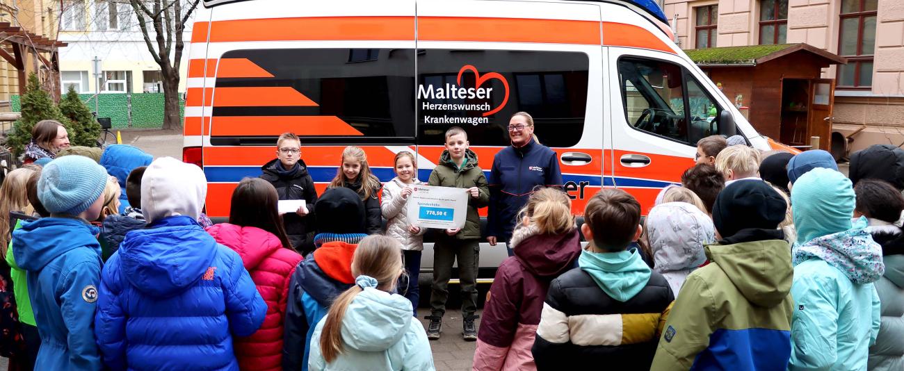 Kinder stehen vor Herzenswunsch-Krankenwagen